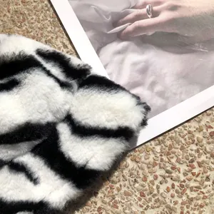 Close-up detail of soft black and white striped faux fur plush bucket hat for women