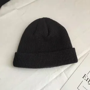 Detailed view of the texture and style of a black short knit beanie for autumn and winter