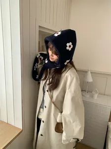 Dettaglio di sciarpa con cappuccio in peluche blu scuro con motivi floreali da donna
