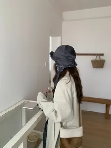 Vue de côté d'une femme portant un bonnet d'aviateur en daim gris avec cache-oreilles
