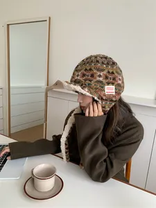 Close-up of woman wearing a thick Fair Isle patterned winter trapper hat with ear flaps