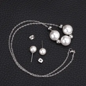 Détail du collier de perles fantaisie et boucles d'oreilles sur fond en cuir noir