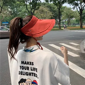 Vue de style de vie en plein air d'une femme portant une visière en lin rouge dans la rue