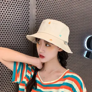 Elegante gorro de pescador de algodón beige con bordados de letras lucido por una modelo