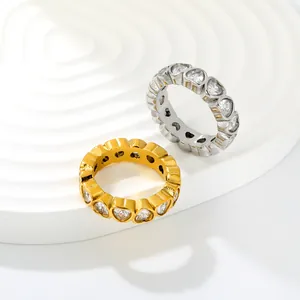 Close-up detail of stainless steel rings with heart-shaped zircon eternity band design.