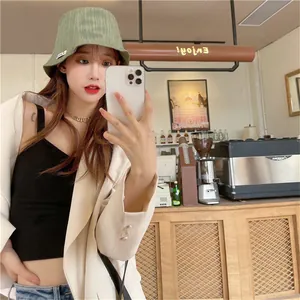 Fashionable green wrinkled bucket hat for sun protection in a chic cafe setting
