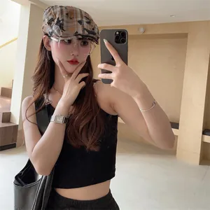 Close-up detail of a vintage distressed plaid beret cap worn by a female model