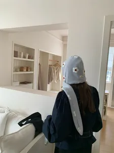 Vista posteriore di una sciarpa con cappuccio in peluche azzurra a fiori caldi
