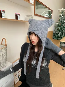 Asian model wearing grey cat ear knitted winter hat and fingerless gloves in a cafe