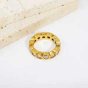 Detailed macro view of a gold-plated stainless steel ring with heart-shaped white zircons.