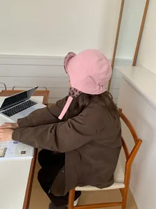 Achteraanzicht roze corduroy pilotenmuts met luipaard pluche voering en bruin jasje