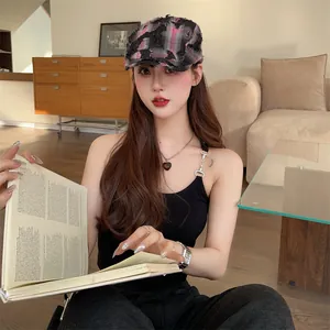 Asian model wearing a vintage distressed plaid ivy cap in a cozy indoor setting
