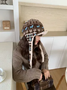 Side view of woman wearing a Fair Isle patterned plush winter trapper hat