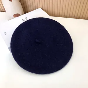 Detailed top view of a classic navy blue wool felt beret for women on white background