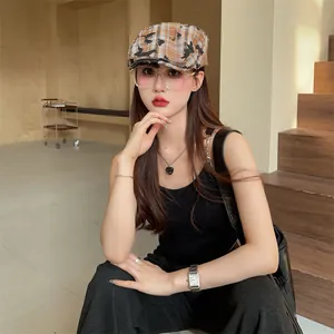 Close-up of a vintage distressed plaid newsboy hat worn by a model in a studio