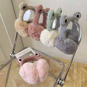 Cozy plush frog earmuffs for women in multiple colors displayed on a stylish chair