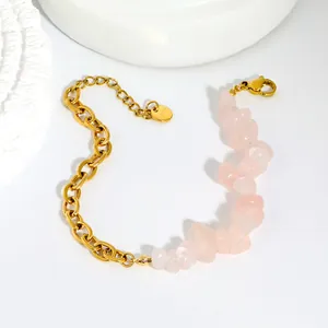 Détail d'un bracelet en acier inoxydable doré avec des pierres de cristal rose irrégulières.