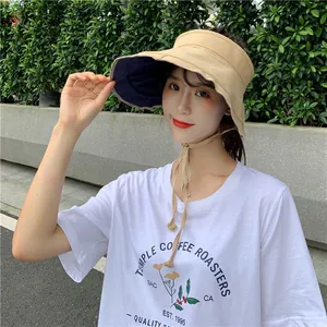 Femme portant un élégant chapeau de soleil en lin kaki et bleu marine à l'extérieur