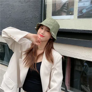 Detailed view of women's pleated green bucket hat with stylish textured fabric finish