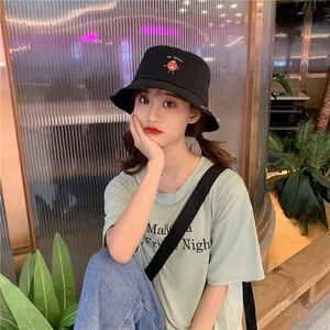 Close-up of a black Japanese-style bucket hat with a cute red tomato embroidery detail.