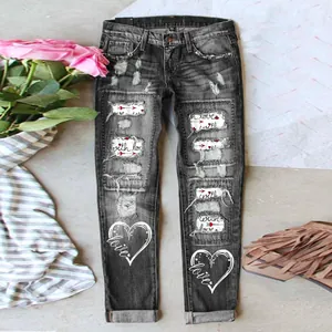 Detailansicht der grauen Jeans mit Distressed-Optik, Herzprints und Liebes-Patches.