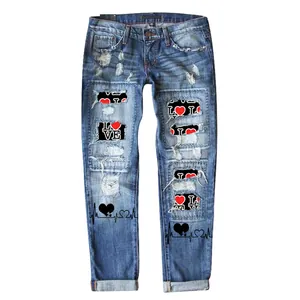 Nahaufnahme einer Damen-Jeans mit geradem Bein, Rissen und roten Herz-Aufnähern.