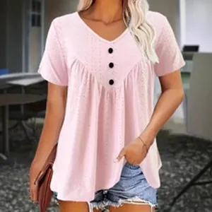 Vue détaillée de la blouse rose à col en V avec des boutons noirs décoratifs sur le devant