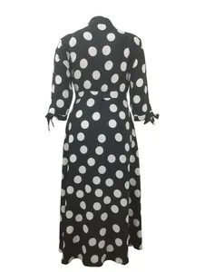 Vue arrière d'une robe longue chemisier classique à pois noirs et blancs avec nœuds.