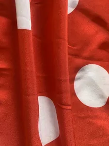 Détail macro d'un tissu imprimé à pois rouges et blancs de haute qualité pour robe
