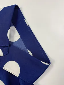 Vue rapprochée de pois blancs sur tissu bleu marine montrant la qualité des coutures.
