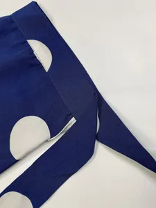Vue macro détaillée d'un tissu bleu marine à pois blancs avec détails de couture