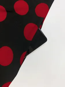 Gros plan d'une poche latérale fonctionnelle sur une robe à pois rouges et noirs