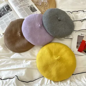 Group of colorful vintage knitted berets in yellow, purple, grey and brown soft textures