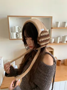 Korean style brown plush earmuffs for women worn in a cozy cafe setting detail view