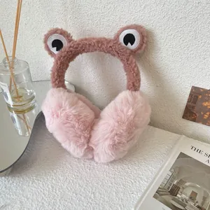 Close-up detail of cute plush frog earmuffs featuring soft pink faux fur ear covers