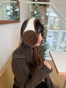 Vue latérale d'une femme portant des cache-oreilles en peluche marron avec rubans