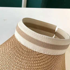 Gros plan d'un chapeau de paille pour femme avec bandeau élastique rayé et toit vide