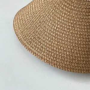 Détail macro d'une visière de soleil en paille tressée avec une texture naturelle.