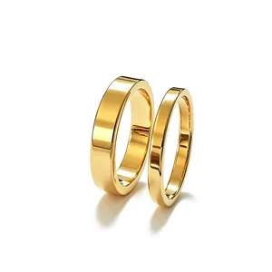Close-up detail of 2.5mm and 4mm polished gold titanium steel rings for couples