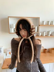 Detail showing cozy fuzzy winter earmuffs with brown striped texture worn by a model
