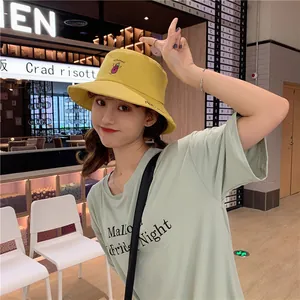 Detailed view of a sweet yellow bucket hat with creative eggplant embroidery on a model