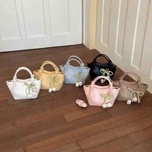 Detailed macro view of stylish handbags in six colors featuring pearl bow charms.