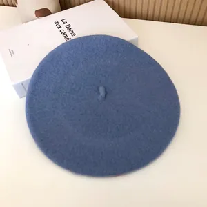 Close-up of a dusty blue wool beret with soft felt texture for a vintage look.