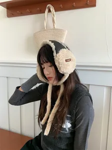Cache-oreilles en peluche avec bordure en cuir et lacets portés pour l'hiver