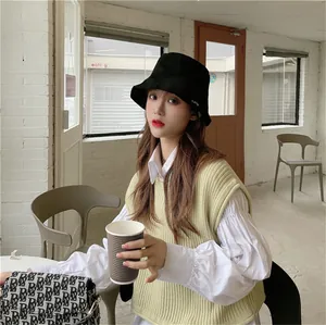 Asian model wearing a stylish black sun protection bucket hat in a modern cafe setting