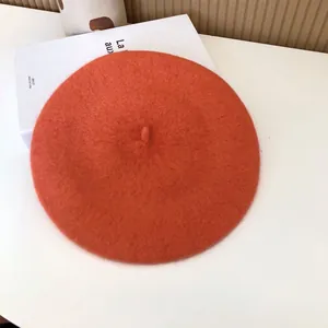 Detailed view of an orange wool beret with soft felt texture for autumn and winter