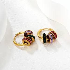 Detailed macro shot of gold stainless steel hoop earrings featuring multi-color crystal rings