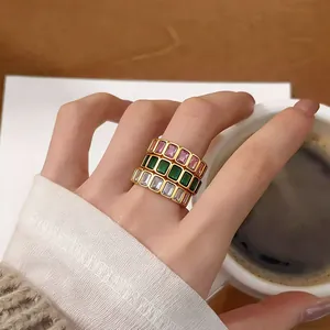 Macro view of three elegant gold-plated rings with colorful baguette-cut zircon stones