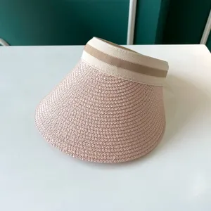 Gros plan sur un chapeau pare-soleil rose tissé pour femmes contre les UV