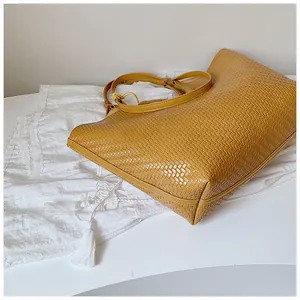 Detailed macro view of the intricate woven texture on a ginger yellow tote bag